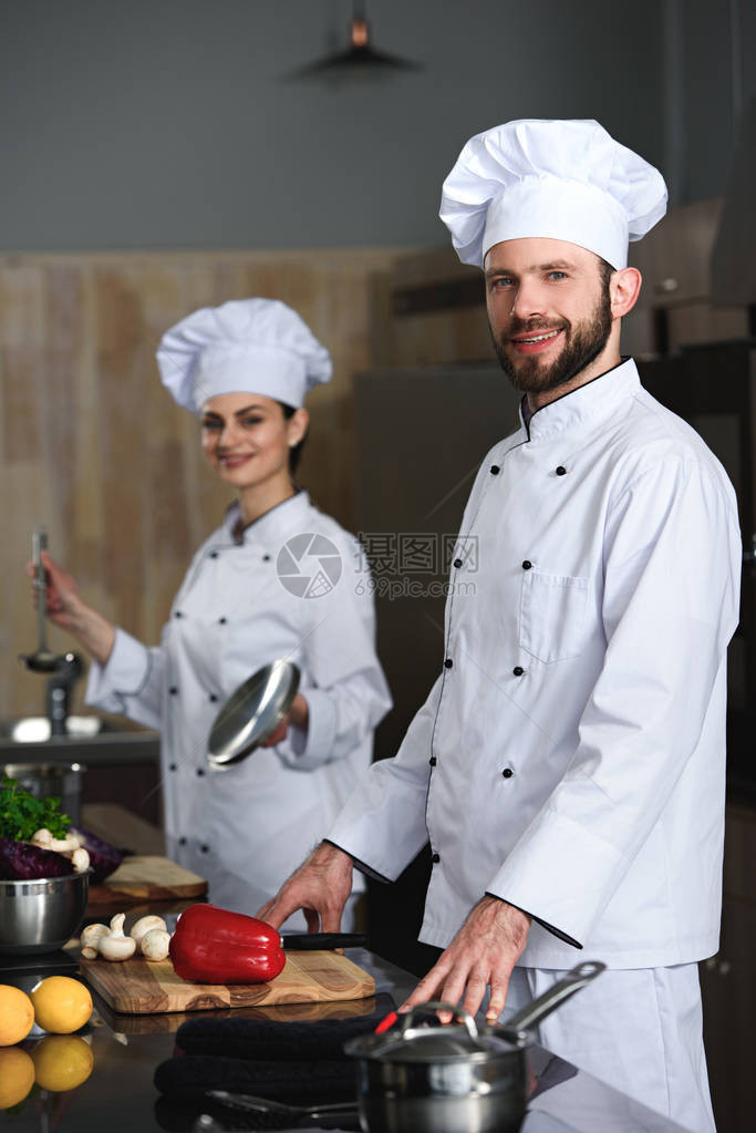 在餐厅厨房做饭的男女专业厨图片
