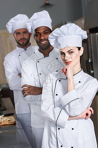 大队委多种族厨师队伍在餐厅厨房穿白制服背景