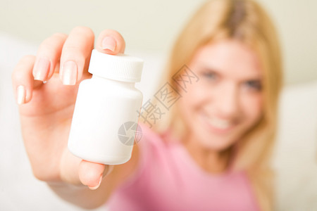 女手握含有维他命的塑料药图片