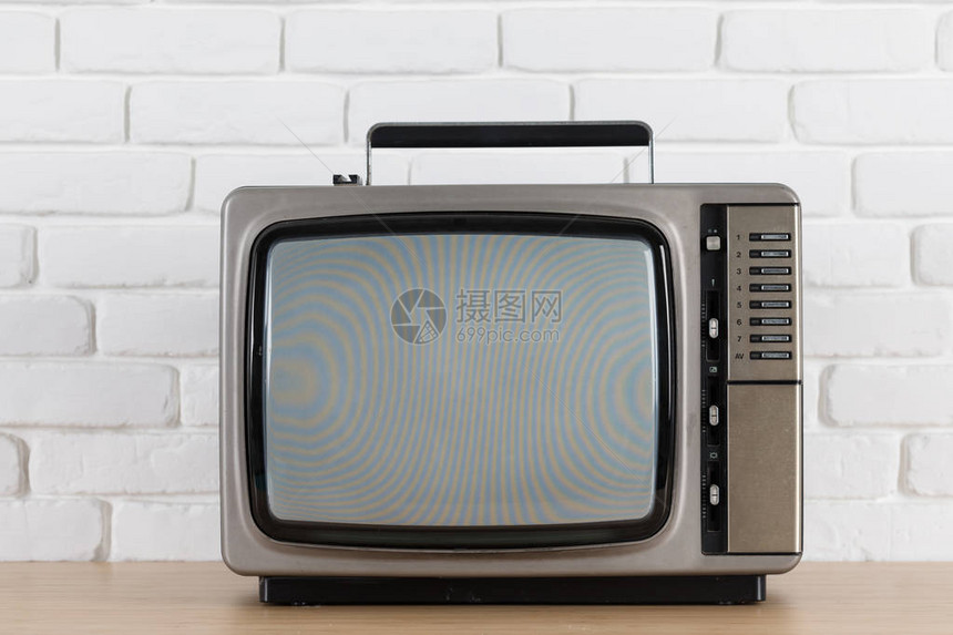 白色砖墙背景上的旧电视图片