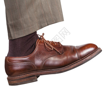 棕色鞋子中男右腿的侧面在白色背景图片