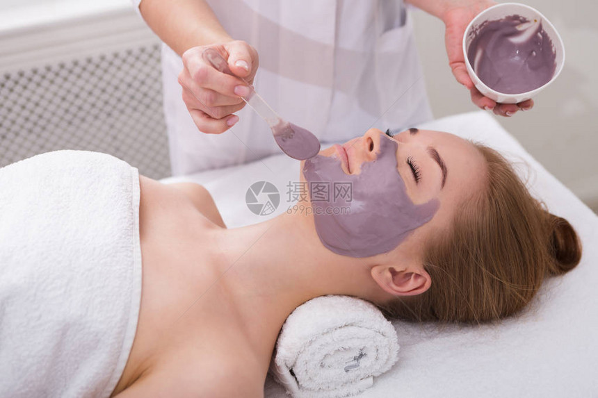 面膜水疗美容护肤女人在水疗沙龙接受美容师的面部滋养面膜图片