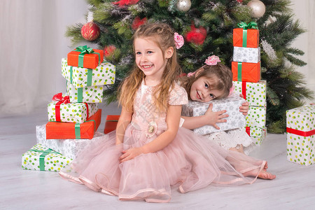 小女孩在圣诞树下看礼物图片