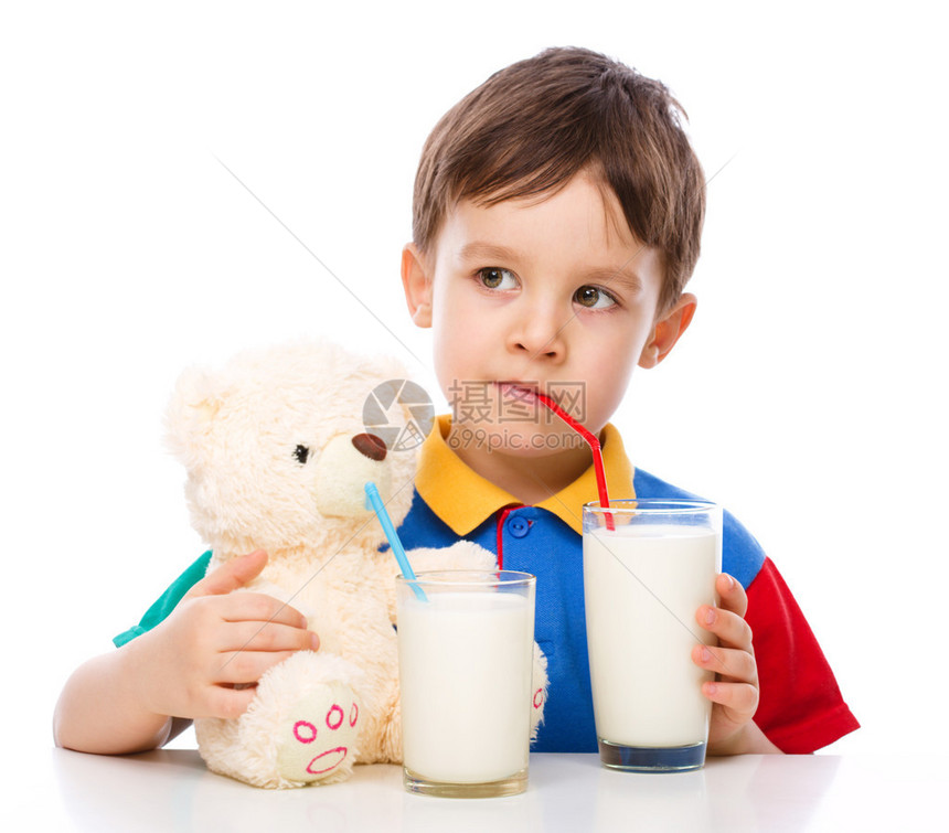 可爱的小男孩喝牛奶用饮稻草孤图片