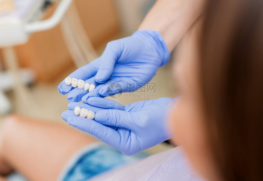 牙科医生向病人展示瓷冠关闭有选择的焦图片