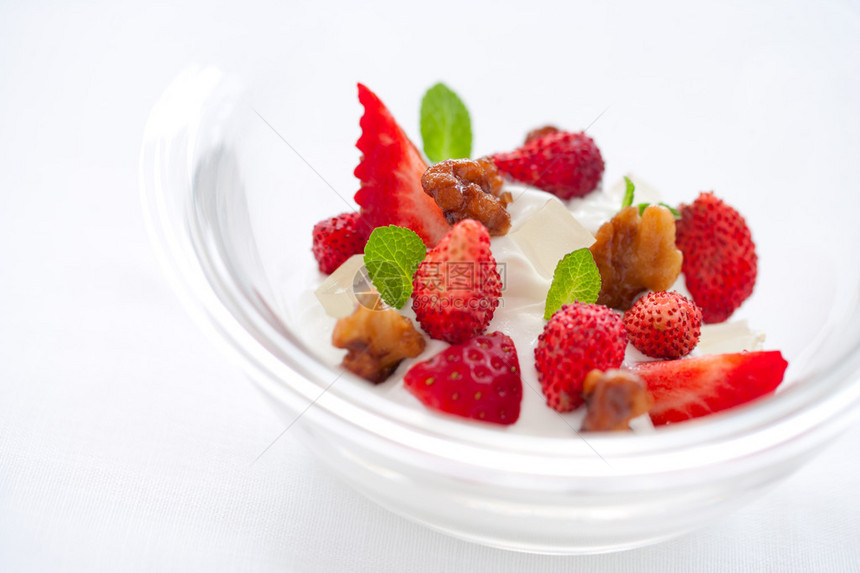酸奶甜点配草莓和焦糖坚果酱的特写图片