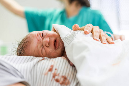 新生儿婴男孩在背景中与医院工作图片