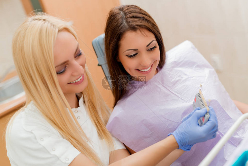 牙医向女病人展示瓷冠图片