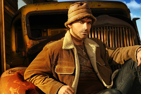 棕色的年轻男模和生锈的旧卡车对背景图片