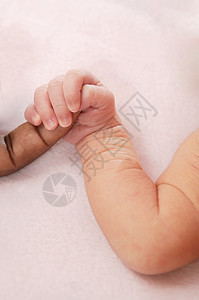 手握着非洲手指的小幼婴儿caucacia图片