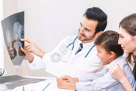 医生将X光照片展示给住院小男孩看图片