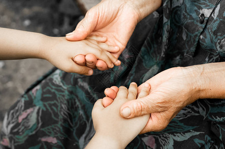 一个小女孩和一个老祖母的手小孩的手牵着老人世界仁慈日概念和成背景图片