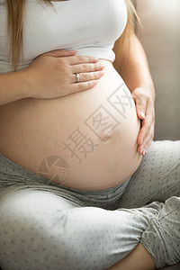 孕妇手放在肚子上的特写照片图片