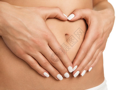 怀孕或饮食概念女双手在胃部形成心图片