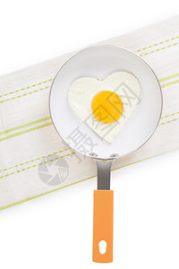 在白色背景上隔绝的煎锅上的心形炒鸡蛋图片