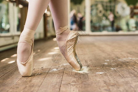 芭蕾舞女演员站在脚趾上芭蕾舞女演员在舞厅里穿着白色尖头舞腿的特写镜头图片