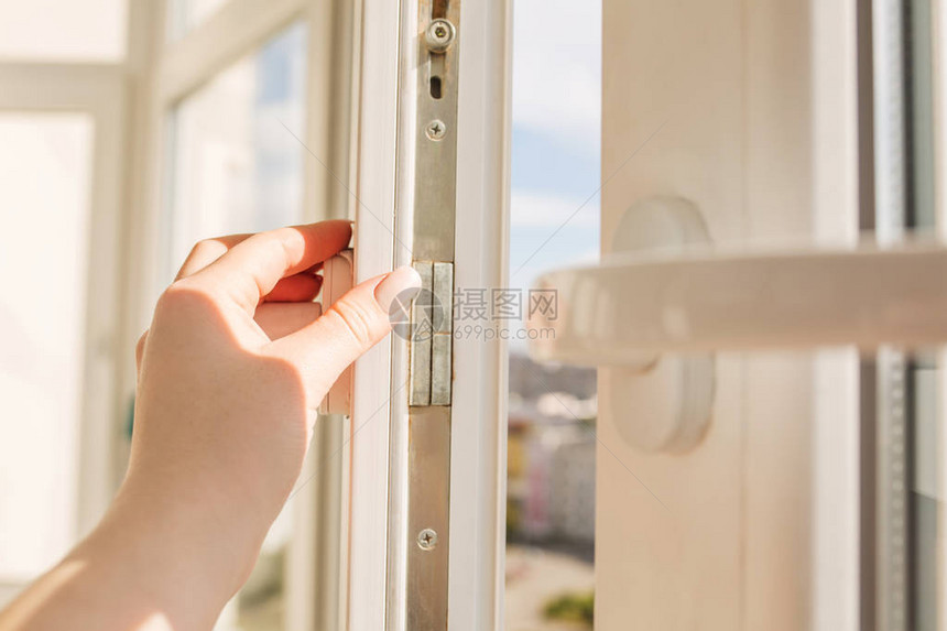 女在阳光明媚的日子里在高楼大背景上打开塑料黑图片