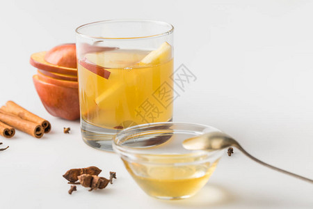 白桌上碗里的一杯苹果酒和蜂蜜图片