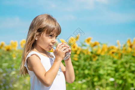 儿童在田野背景上喝水图片