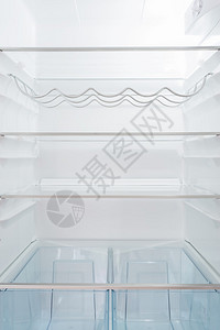 干净的空冰箱白色的墙壁和玻璃架子背景图片