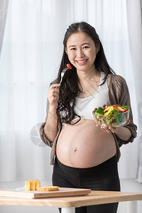 亚洲孕妇与健康的蔬菜一起图片