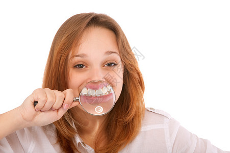 年轻女用放大镜的牙齿孤立图片