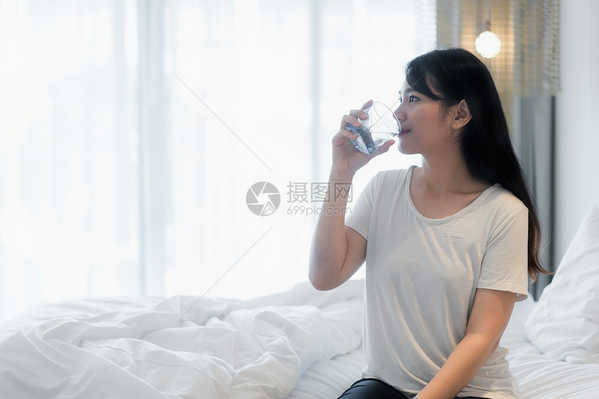 亚洲女人早上醒来后喝图片