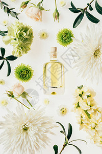 上面有一瓶香芳水四周是鲜花和白图片