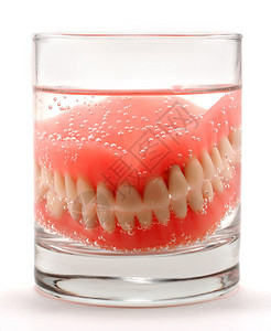 牙体缺损假牙放在一杯水中清洗背景