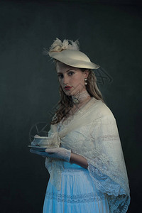 维多利亚时代年轻女子端着一杯茶的肖像图片