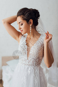 年轻新娘闭着双眼穿着婚纱的结婚礼服在图片