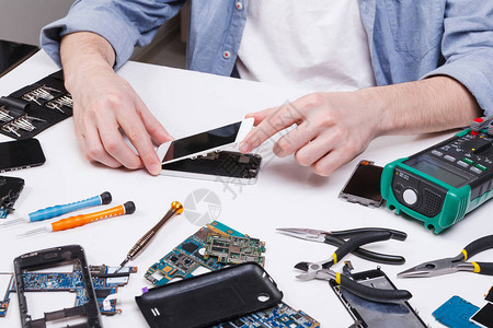 修理工拆卸智能手机供检查技术员修补破损电话电子维修图片