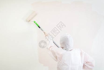 穿防护服的画家在墙上刷漆图片