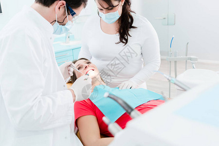 牙科医生和护理人员在对孕妇进行外科手术时为图片