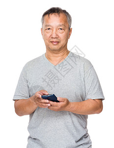 穿着灰色t恤的亚洲老人拿着手机图片