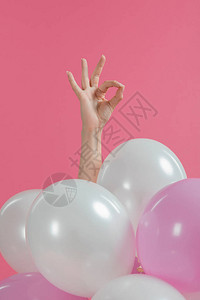 女手在粉色和白色气球上显示好的标志图片