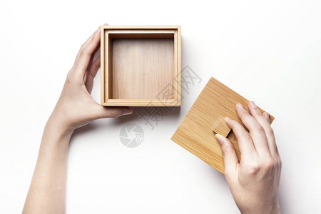 女人手握着木头bamboo盒图片