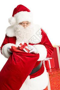 圣诞快乐的圣诞老人拿掉圣诞礼物从一个大袋子图片
