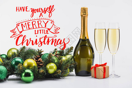 白色背景中的香槟圣诞花环和礼物的酒瓶和酒杯图片