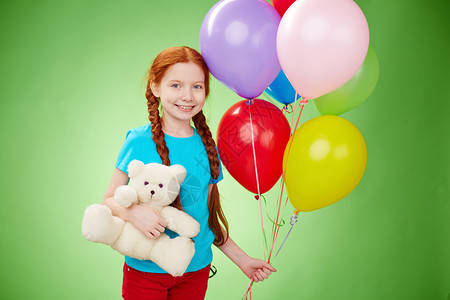 微笑的女孩与泰迪熊和气球图片