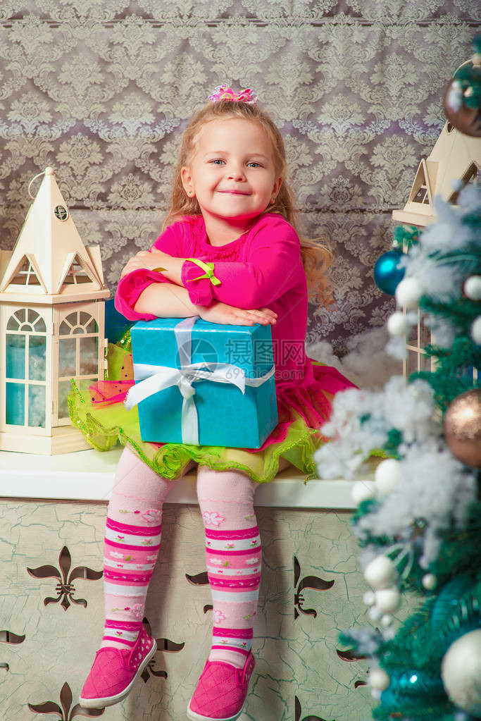 金发可爱的小女孩坐着微笑几乎被装饰的圣诞图片