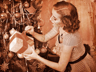 在圣诞树下接受礼物的女人黑色背景图片