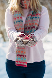 穿着针织手套的年轻女士在冬季公园拿着图片