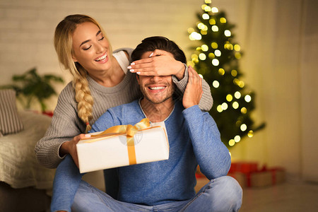 快乐的女子为丈夫圣诞惊喜图片