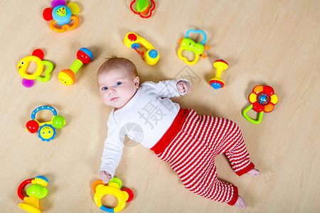 可爱的新生婴儿玩很多五颜六色的拨浪鼓玩具背景图片
