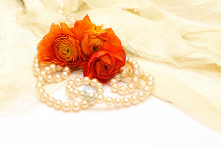 花朵和珍珠放在精细的蕾丝和白背景图片