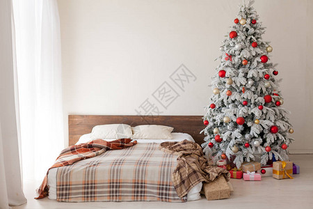 在卧室的圣诞树和假期礼物加兰白图片