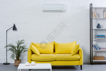 现代室内黄色沙发和挂在白墙上的图片