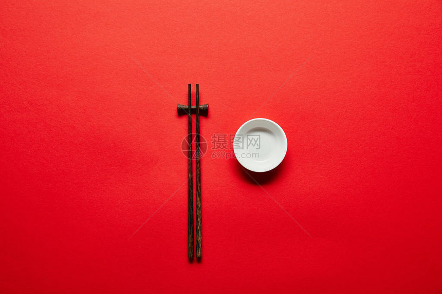 红色背景下排列的筷子和空图片