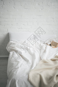 床上的眼镜和书还有白色的毯子和枕头图片